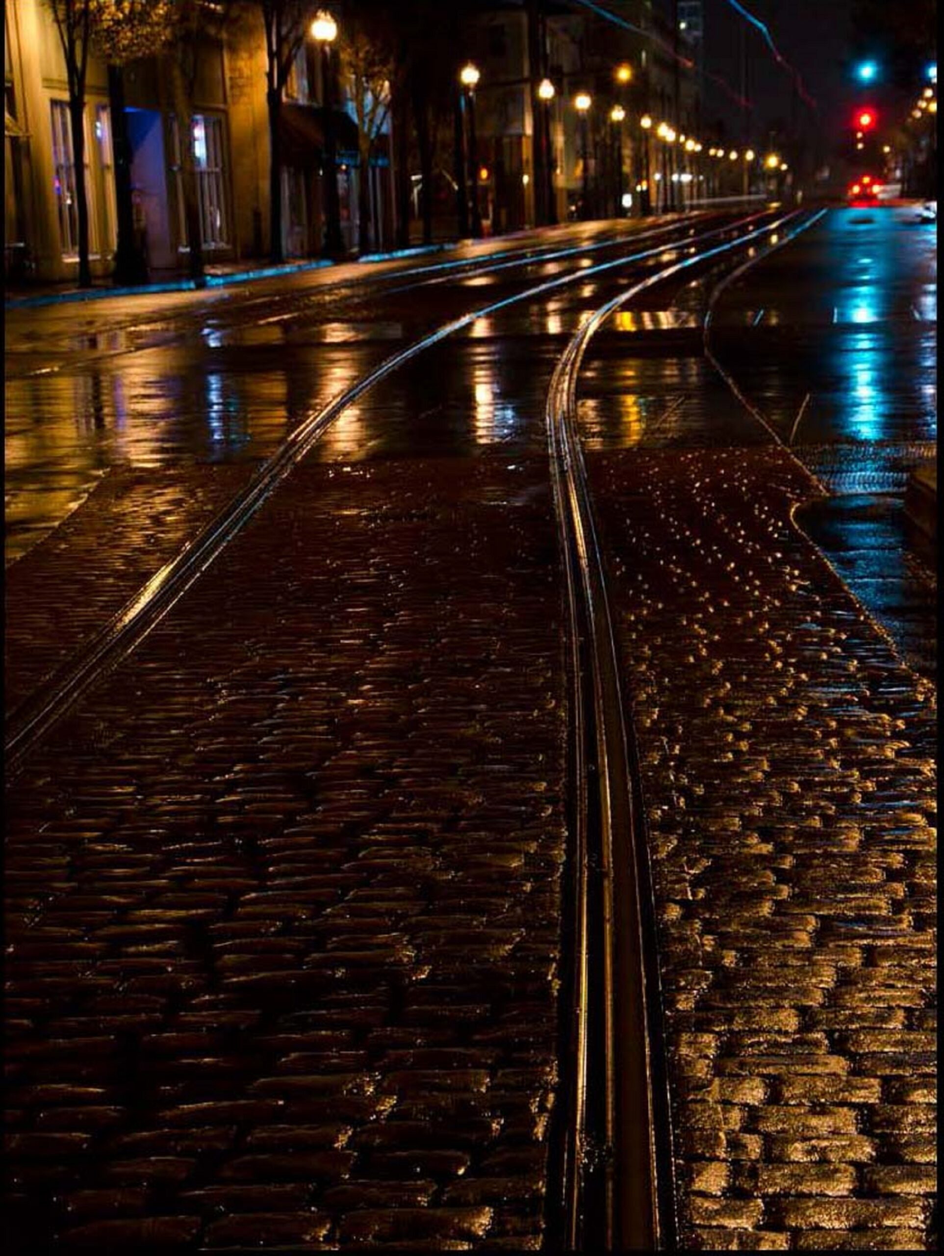 Photograph depicting a night view of the light rail tracks found on 3rd and Washington in downtown Hillsboro.