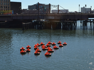 Submerged a herd of 22 bright orange figures in the Fort Point Channel in Boston’s harbor