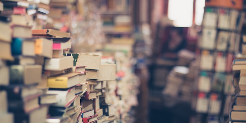 Stacks of books in a room. Some out of focus