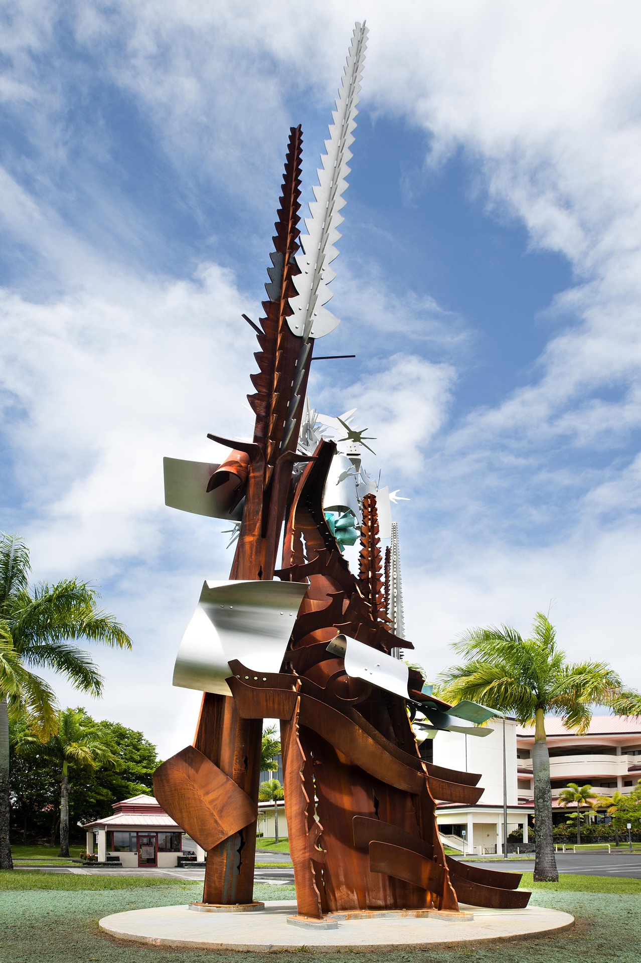 Makalii (Pleiades) by Albert Paley a large metal structure infront of a building pointing up toward the sky.