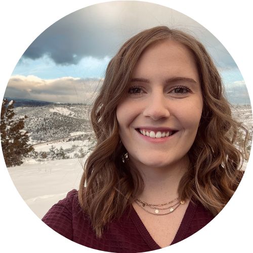 Headshot of Justine Chapel standing outside in front of a snowy mountainous background