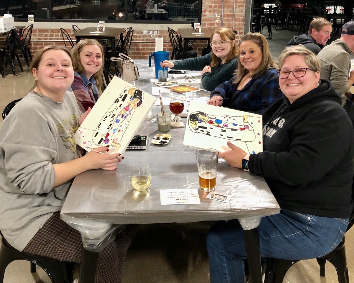 An image of Galesburg Community Arts Center employees doing arts and crafts at a table