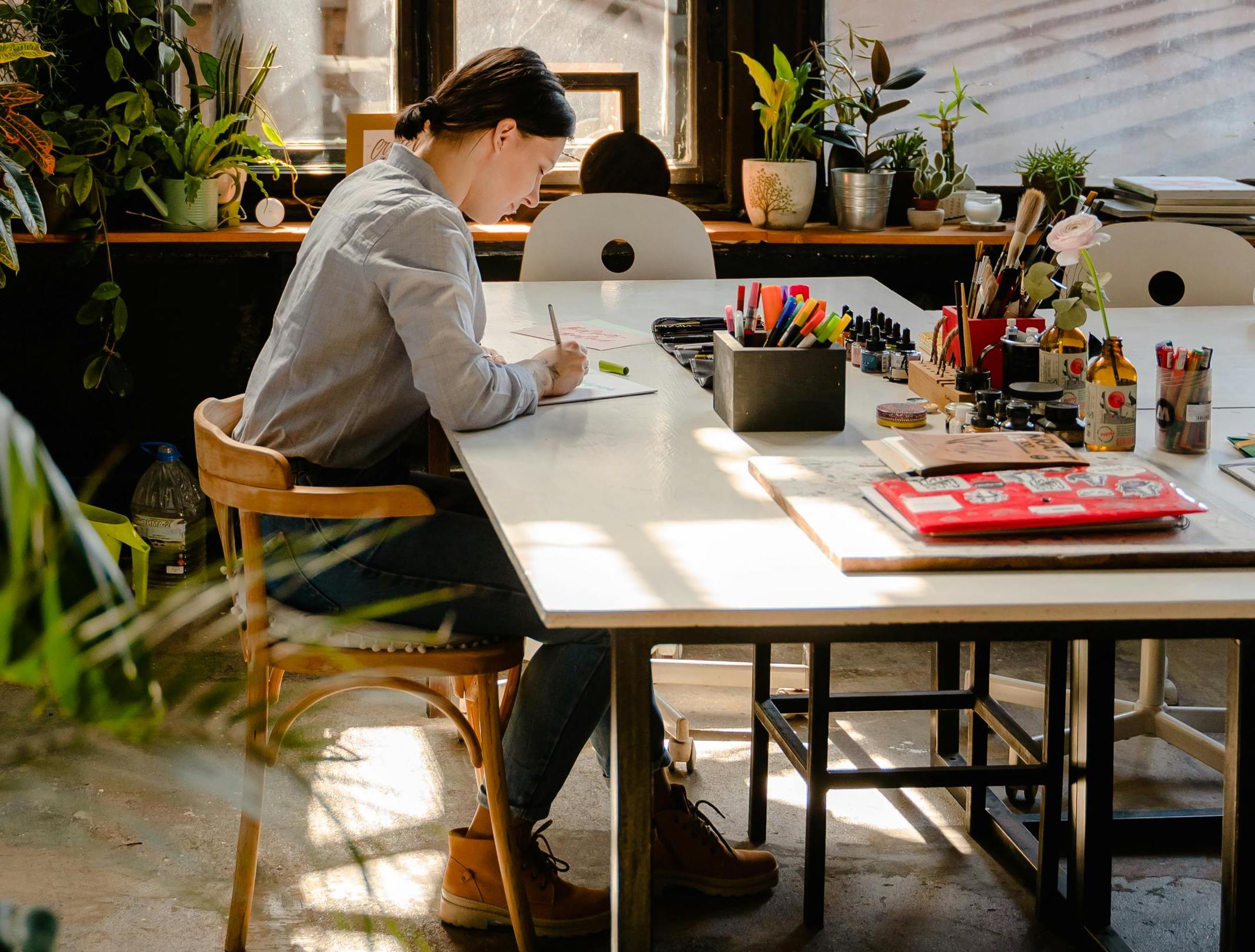 Image of an artist sitting at a desk and writing