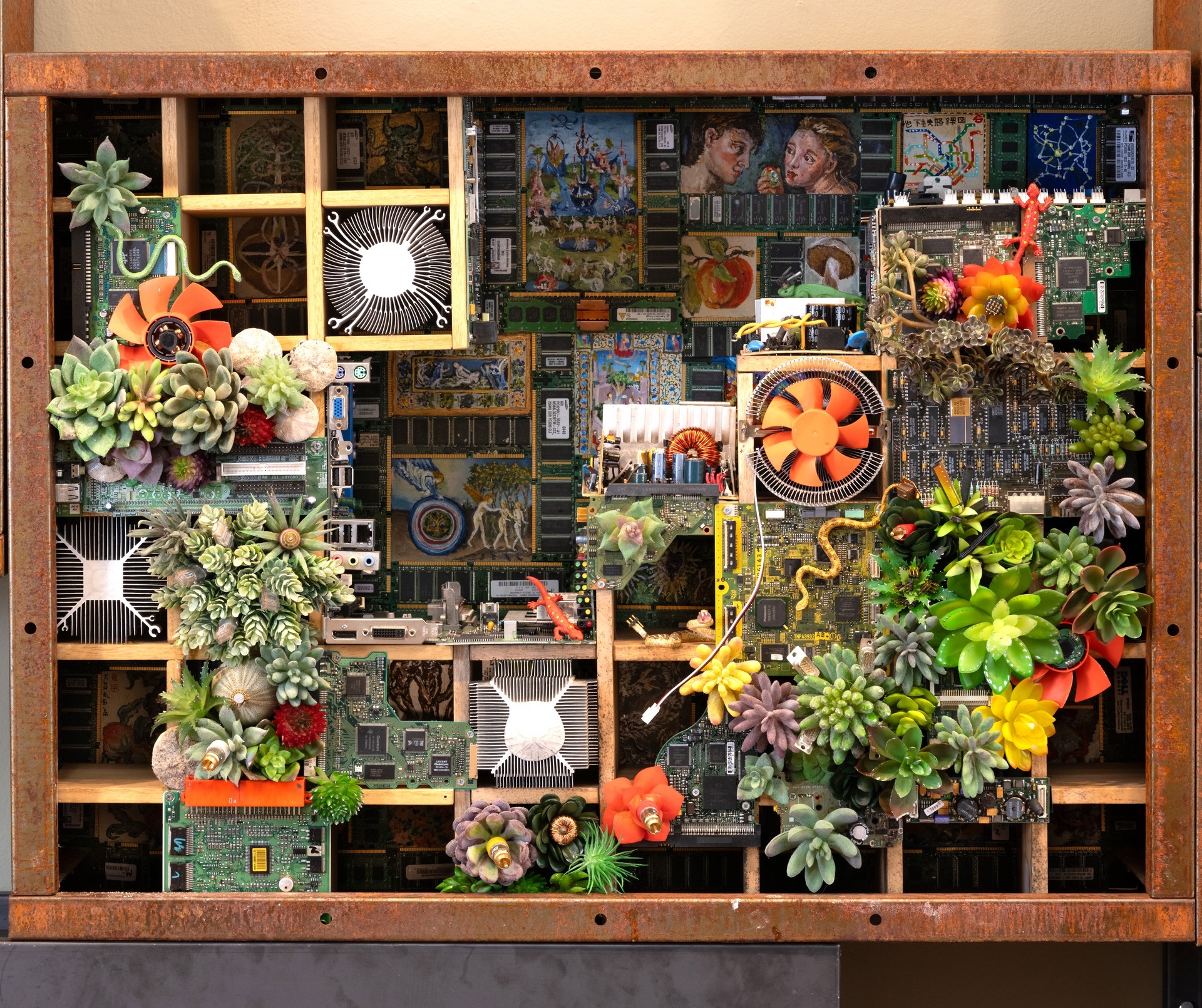 Mixed media artwork with electronic components and artificial succulents in a grid frame.